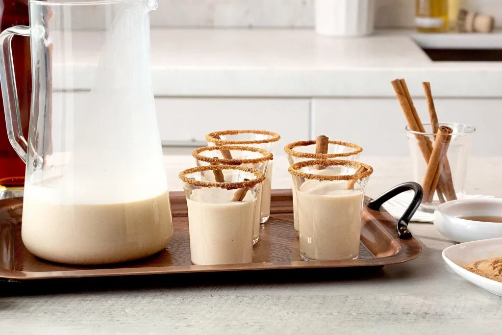 Bacardi coquito garnished with cinnamon powder and sticks. 