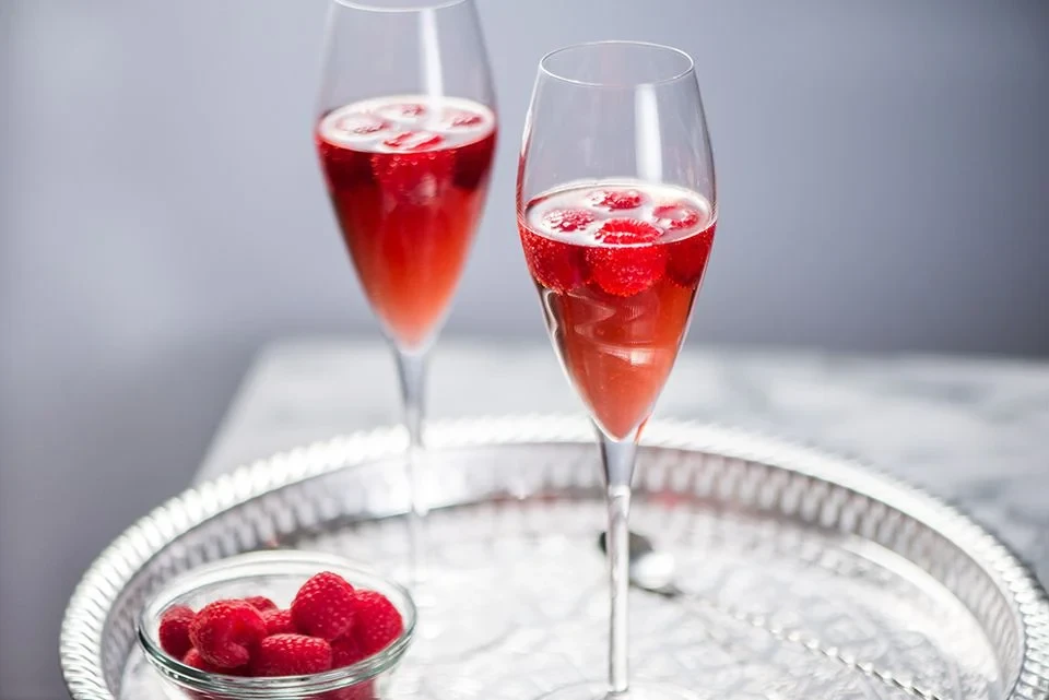 Kir royale with raspeberries on the side
