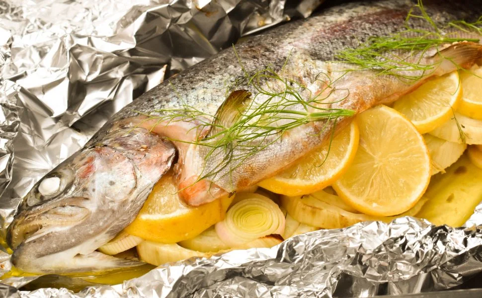 Sea bass with lemon slices and dill leaves