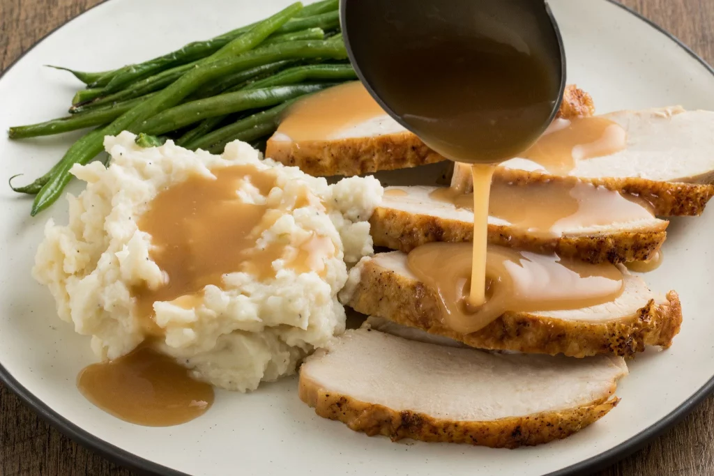 Turkey with gravy, mashed potatoes, and beans
