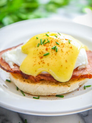 Eggs Benedict on an English muffin with Canadian bacon and poached egg and hollandaise sauce.