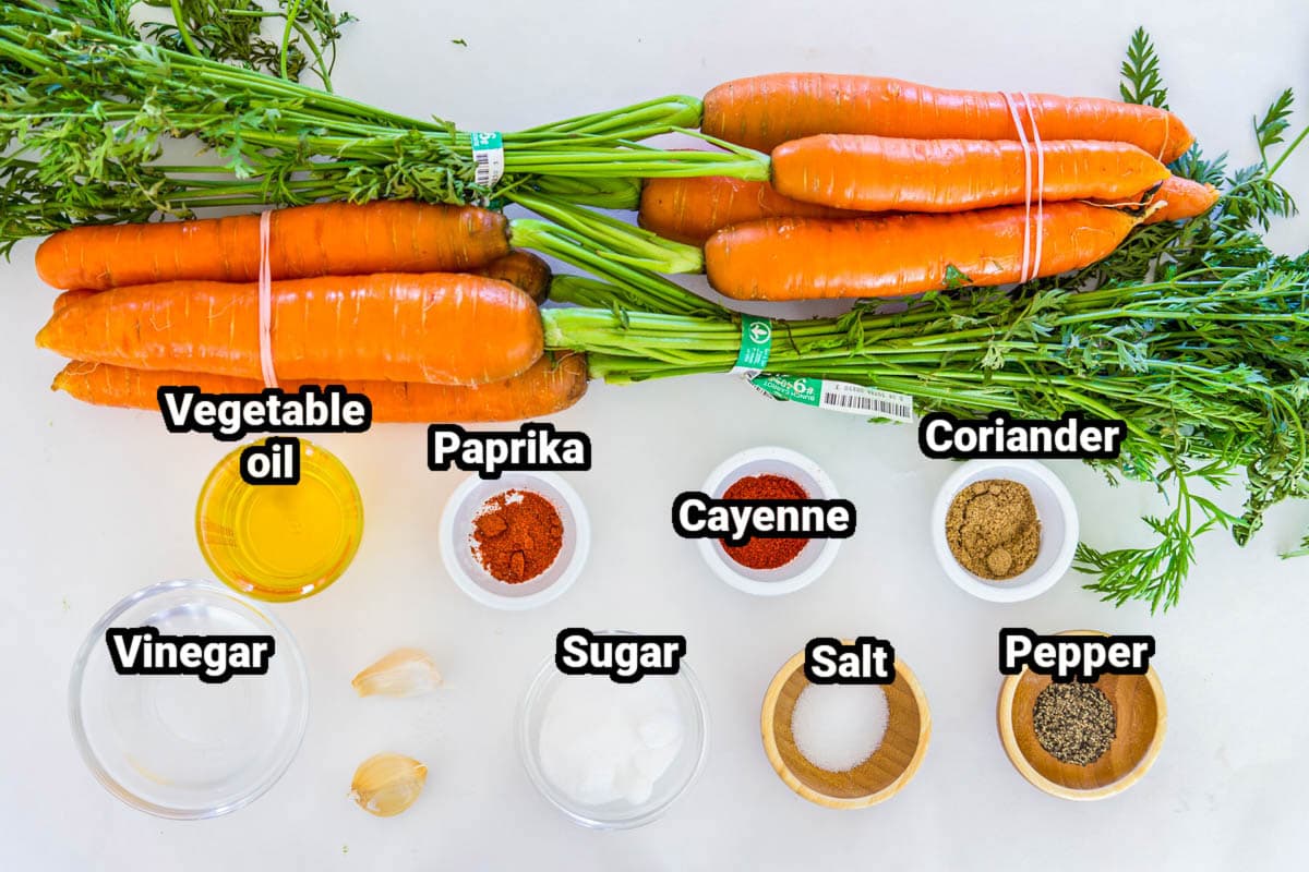 Ingredients for Shredded Carrot Salad: carrots, oil, vinegar, paprika, cayenne, coriander, sugar, salt, pepper, and garlic cloves.