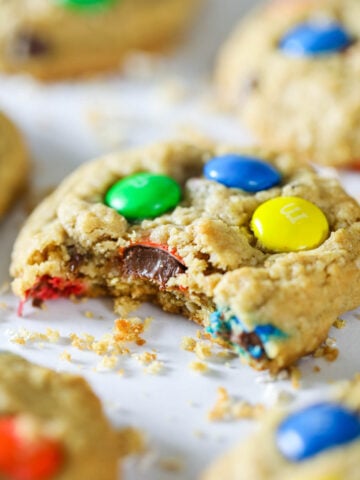 Close up of Monster Cookies, one missing a bite.