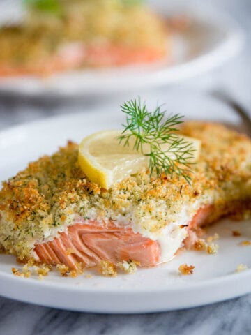 Vertical image of a plate of Panko Crusted Salmon topped with dill and lemon