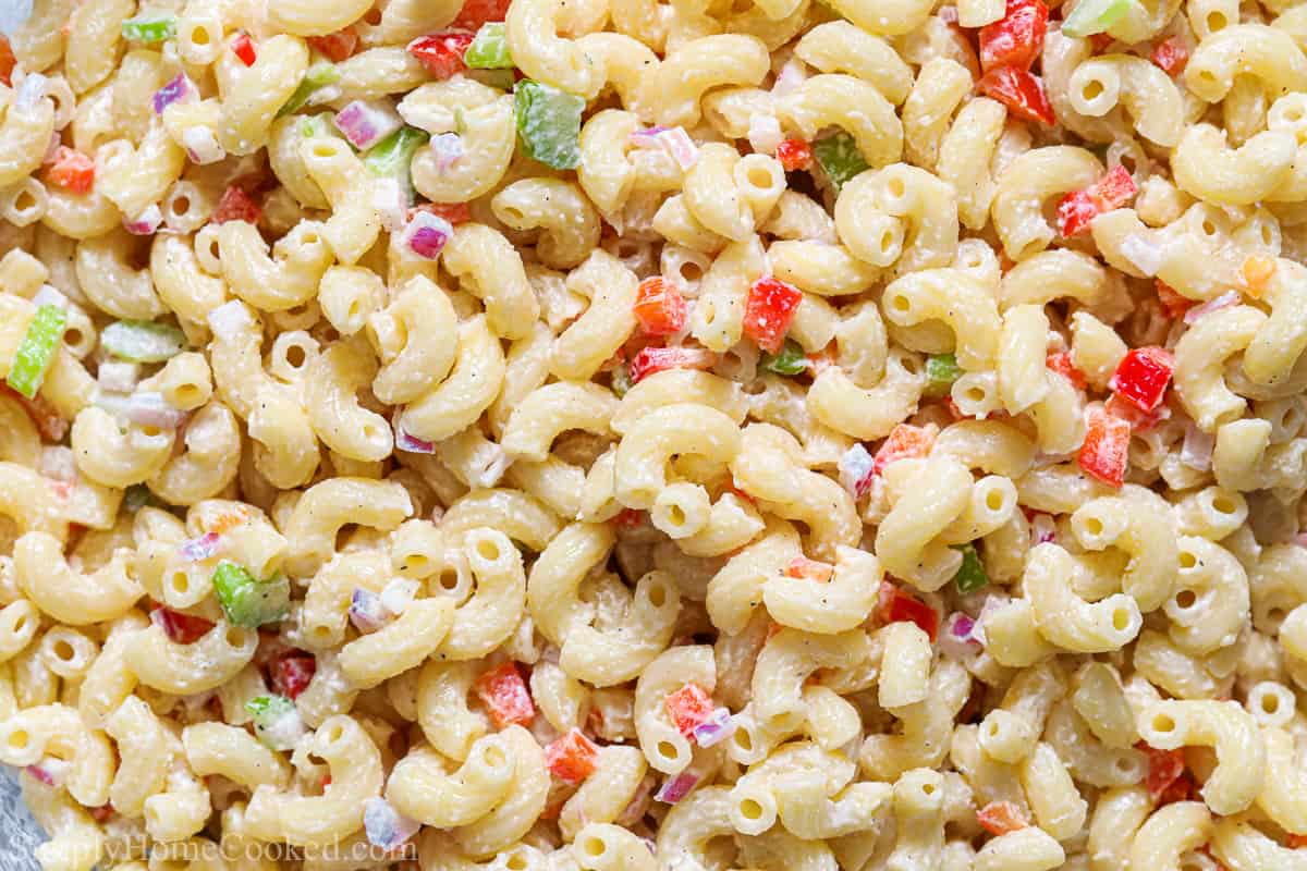 For an easy to prepare side dish, try this Classic Creamy Pasta Salad. It's smooth and flavorful, with crispy diced vegetables to give it amazing texture. #creamypastasaladrecipe #bestcreamypastasalad #homemadepastasaladrecipe #bestclassiccreamypastasaladrecipe Close up of Classic Creamy Pasta Salad with diced vegetables and elbow macaroni.