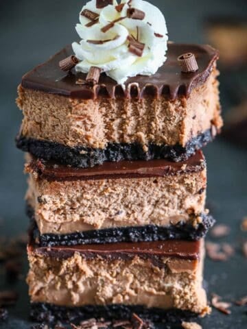 Stack of Chocolate Cheese Cake Bars with whipped cream on top
