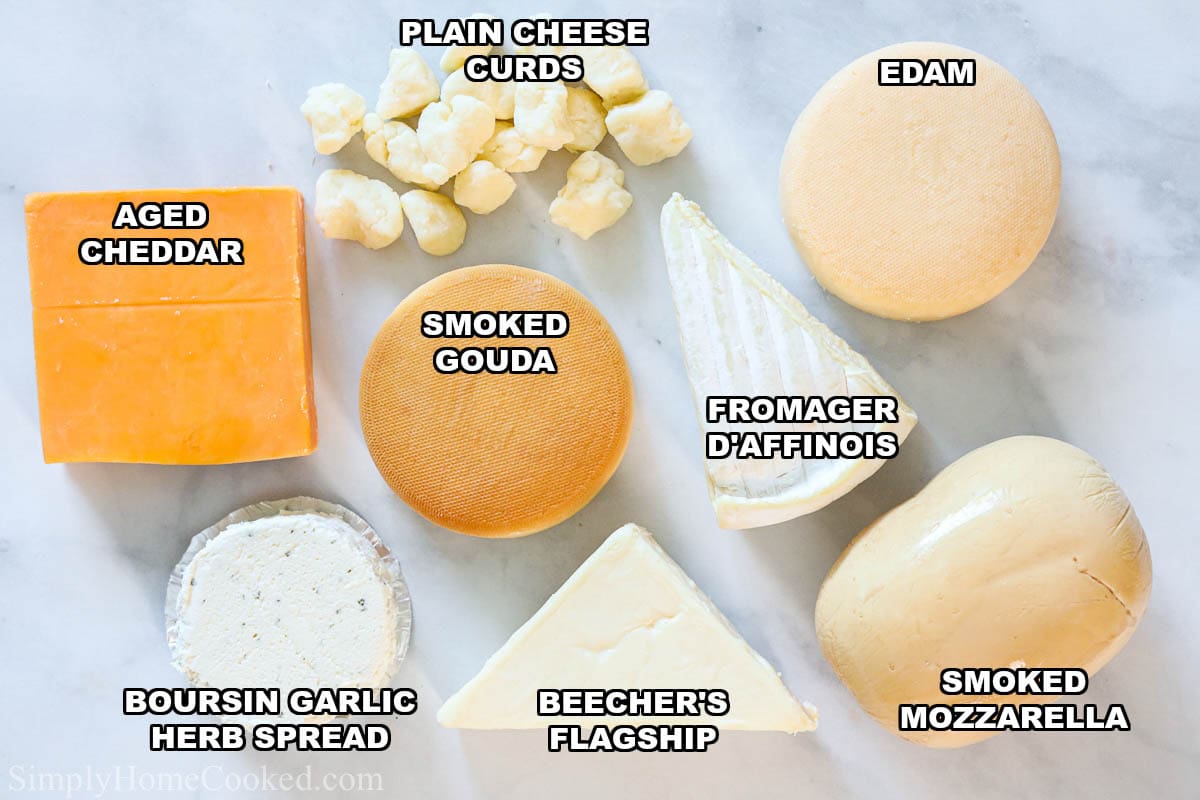Cheeses for an Ultimate Charcuterie Board: aged cheddar, smoked gouda, plain cheese curds, edam, fromager d'affinois, smoked mozzarella, beecher's flagship, and boursin garlic herb spread.