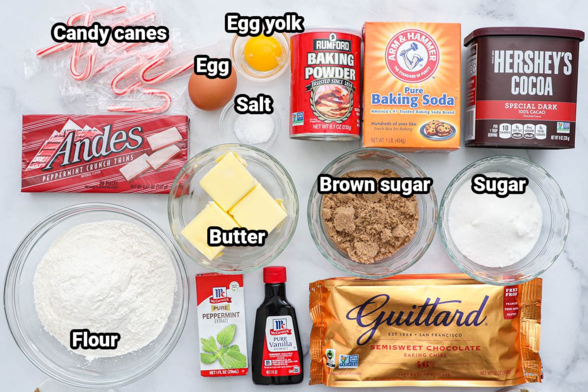 Ingredients for Chocolate Peppermint Cookies: candy canes, Andes candies, flour, egg, egg yolk, salt, baking powder, baking soda, cocoa powder, butter, peppermint extract, vanilla extract, brown sugar, sugar, and semisweet chocolate chips.