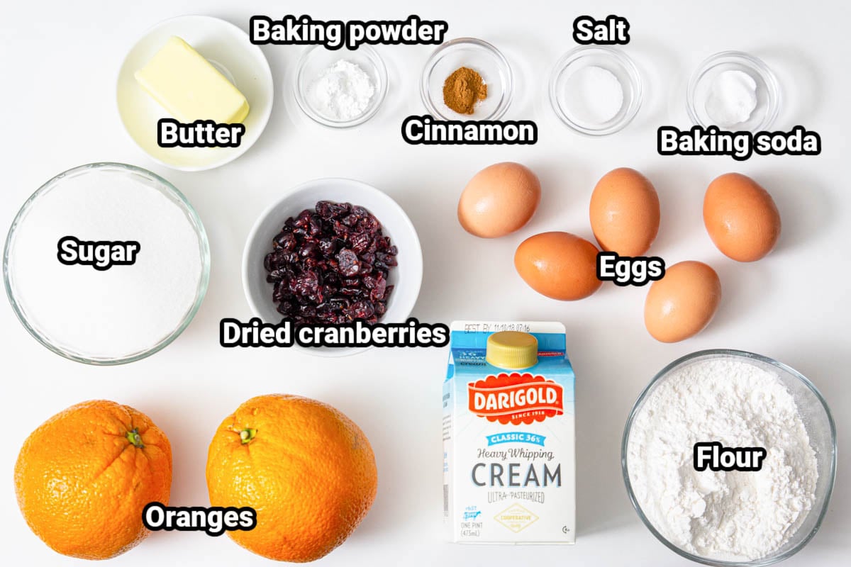 Ingredients for Cranberry Orange Bundt Cake: butter, sugar, baking powder, baking soda, cinnamon, salt, dried cranberries, oranges, cream, flour, and eggs.