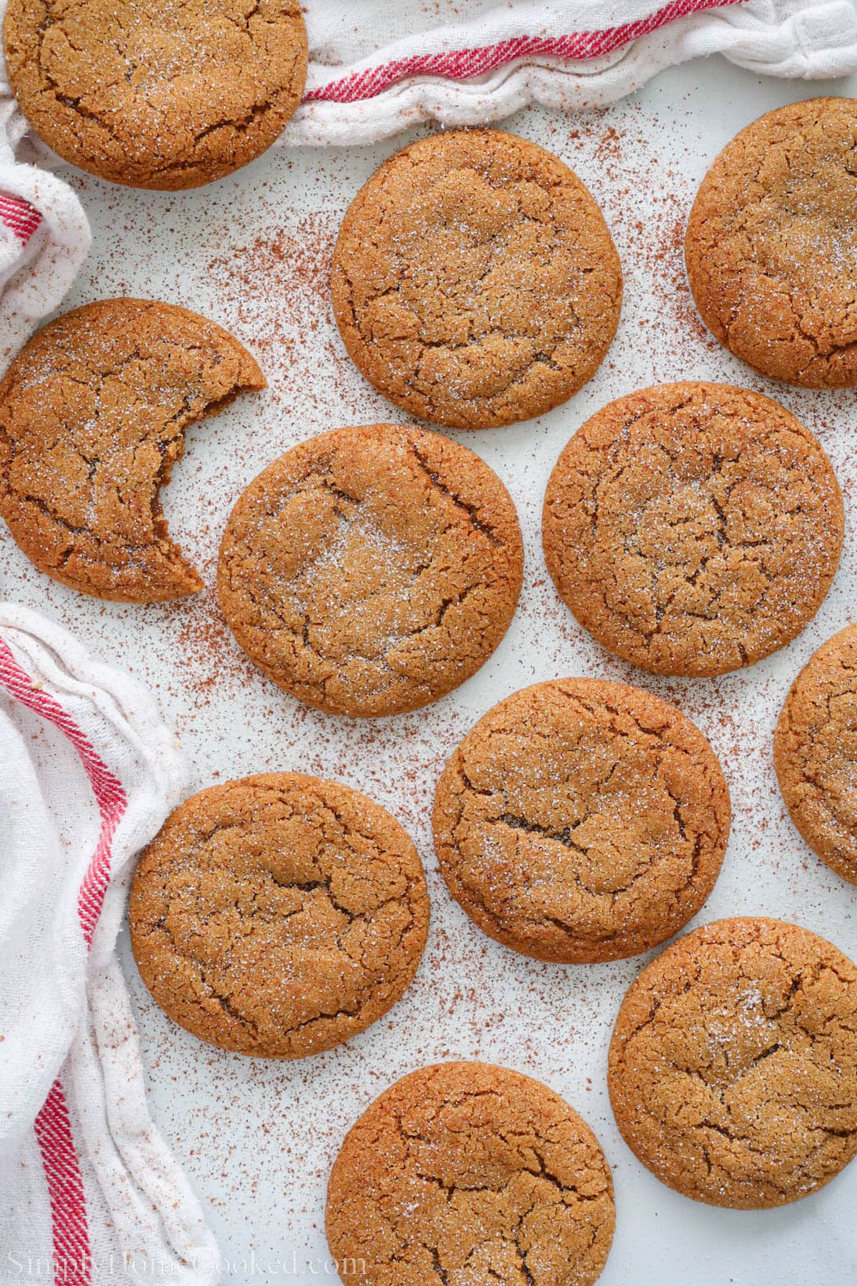 Ginger Molasses Cookies on a towel, one missing a bite.