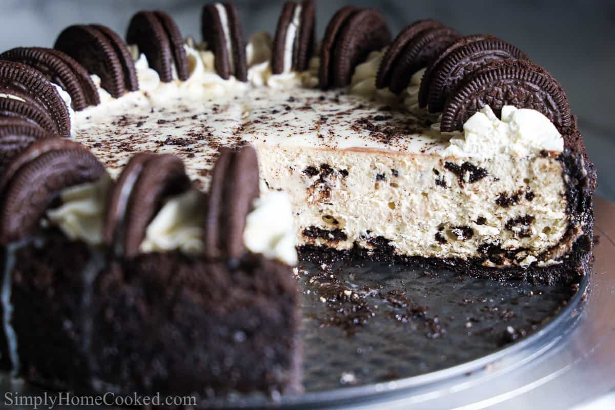 Easy Oreo Cheesecake with a large slice missing and Oreos decorating the top.