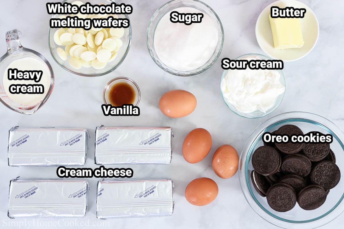 Ingredients for Oreo Cheesecake: heavy cream, cream cheese, white chocolate melting wafers, sugar, vanilla, eggs, sour cream, butter, and Oreo cookies.