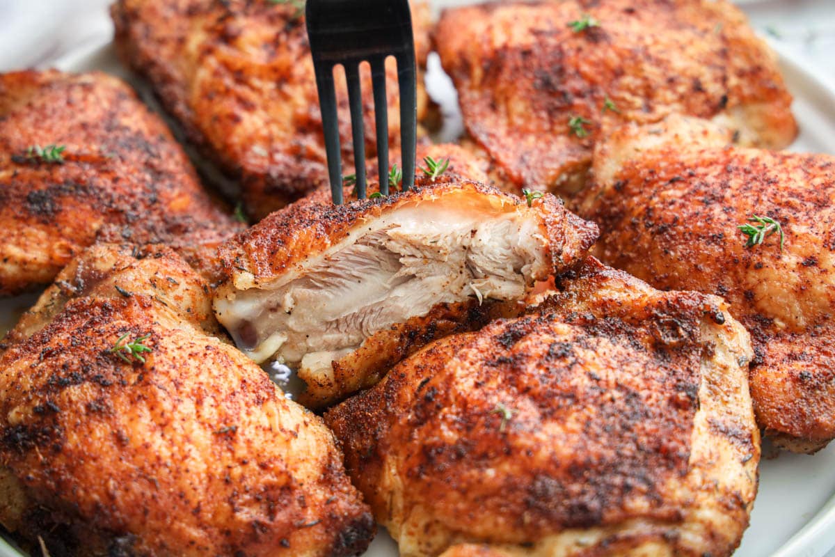 Crispy Baked Chicken Thighs with a fork.